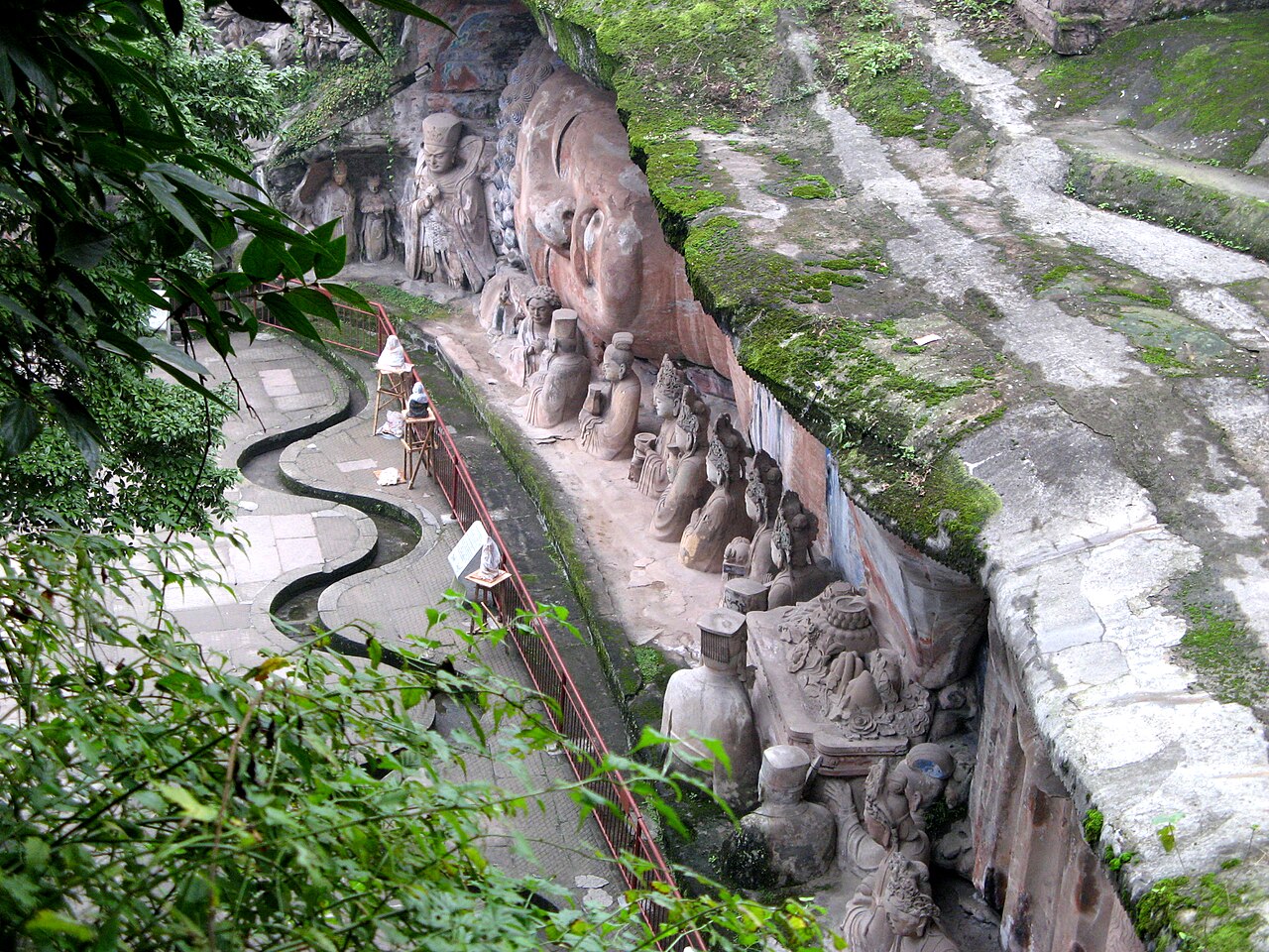 Baodingshan’s reclining Buddha and attendant figures along the cliff beside a visitor path