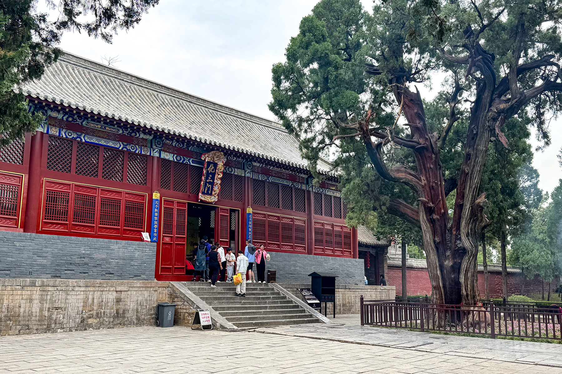Red timber Huasan Gate and a large tree at Zhongyue Temple in Dengfeng