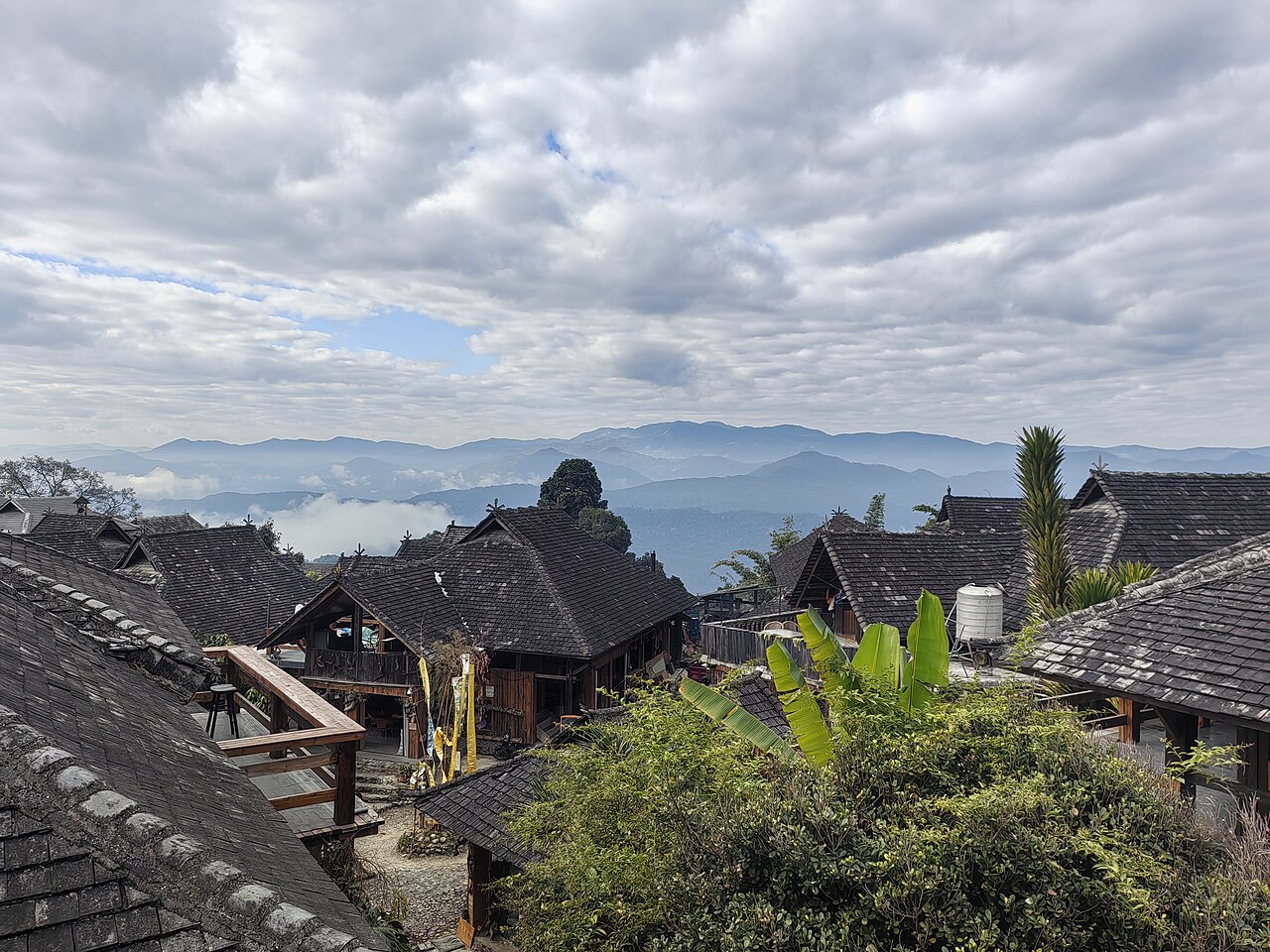 Tiled roofs and timber buildings in Wengji village with mountains beyond