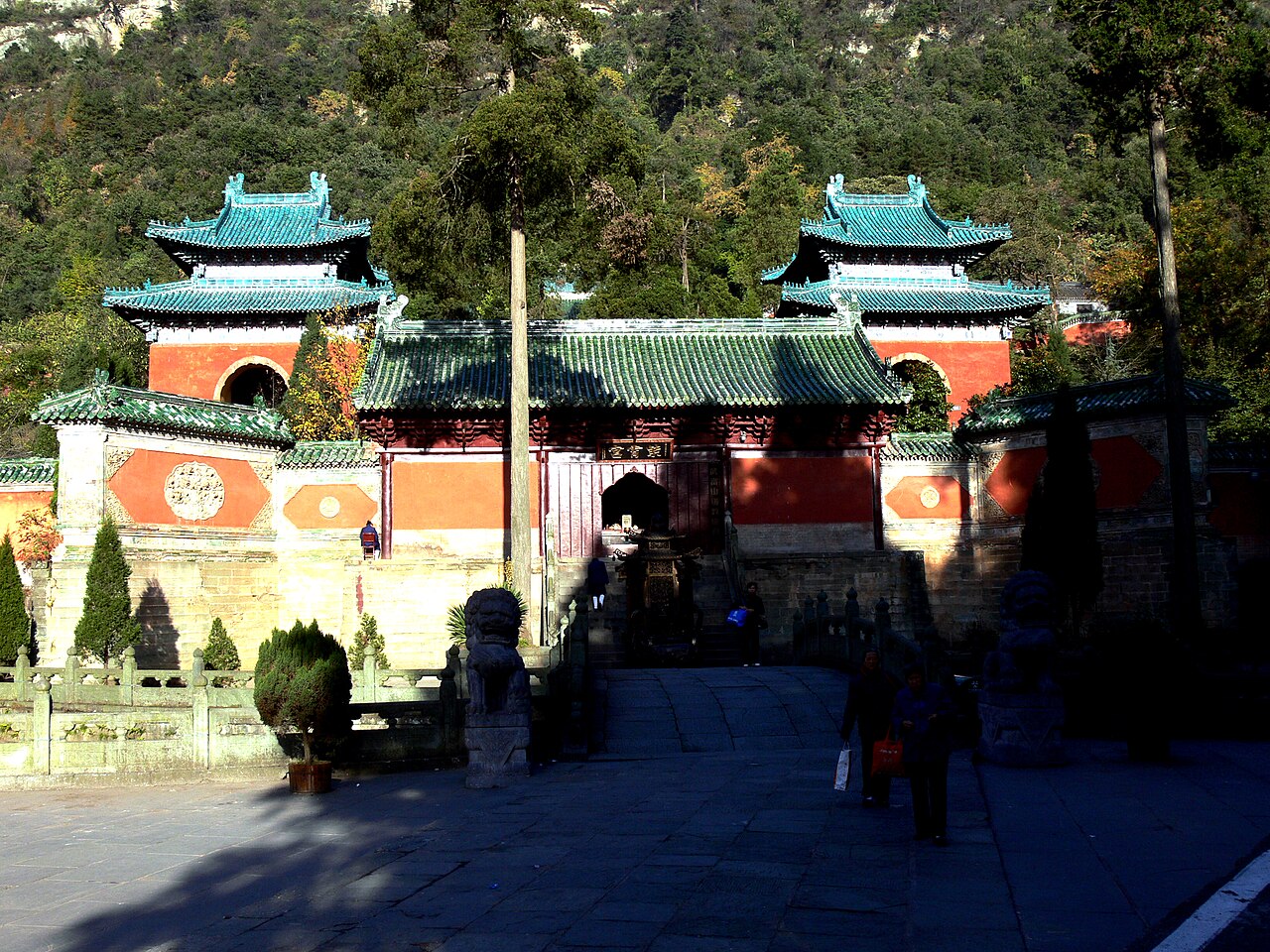 Zixiao Palace entrance with green-tiled roofs, red walls and wooded hillside