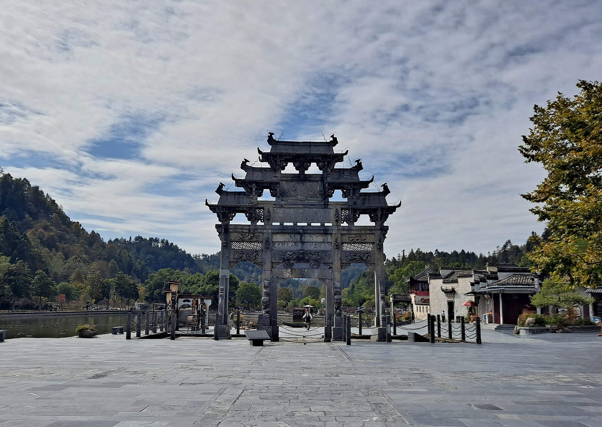 The stone Hu Wenguang memorial archway at Xidi with village houses beyond